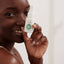 Smiling woman holding Congested Skin Face Serum, a natural serum treatment for acne and blemishes