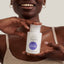 Natural cleansing micellar water with hyaluronic acid, in a bottle held by a smiling woman