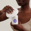 Applying cleansing micellar water to a cotton pad to gently remove makeup
