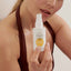 Vitamin C face serum bottle held by model